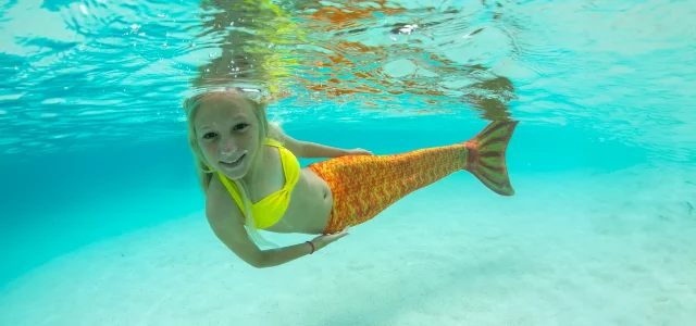 Mädchen mit Schwimmflosse unter Wasser